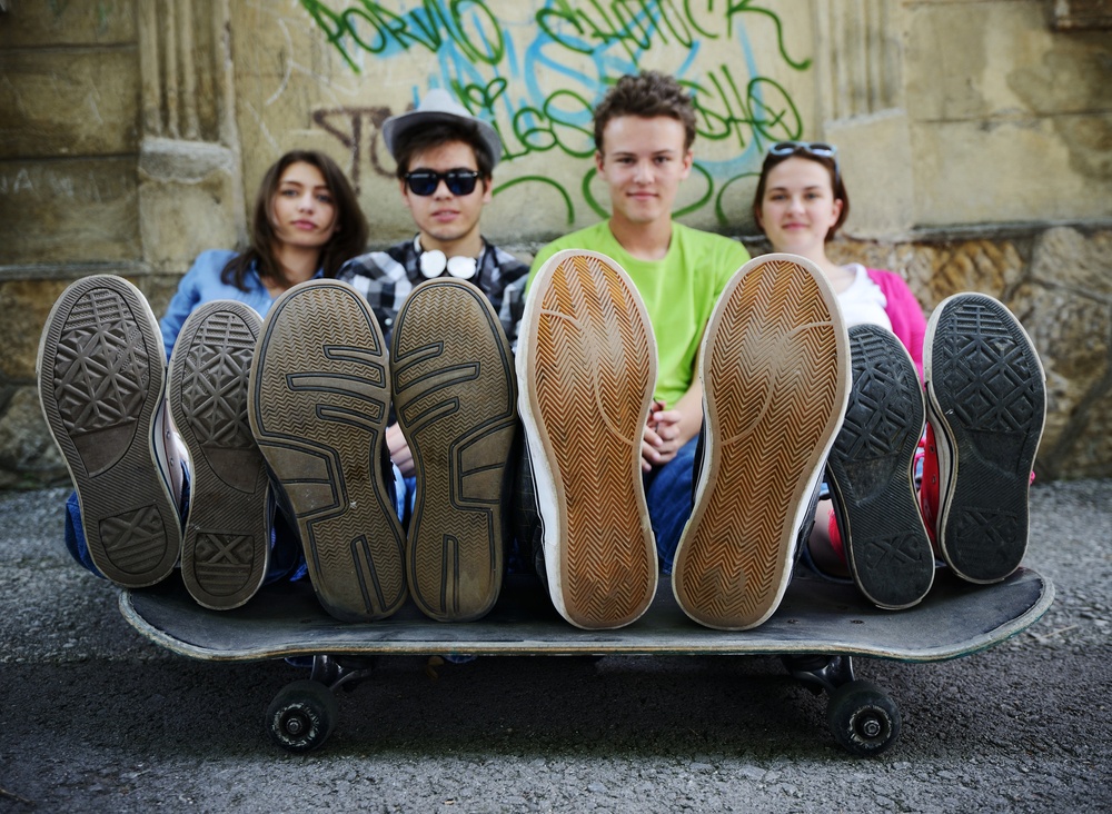 Urban stylish trendy young teenage people with legs on skate